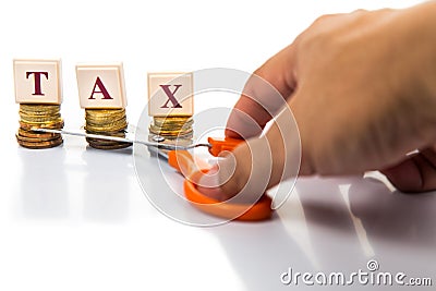Cut taxes concept with coins and scissors Stock Photo