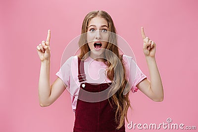 Cute active and charismatic young woman with wavy hair, small scar and tattoo on arm open mouth with amazement and Stock Photo