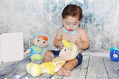 Cute adorable baby playing with dolls Stock Photo