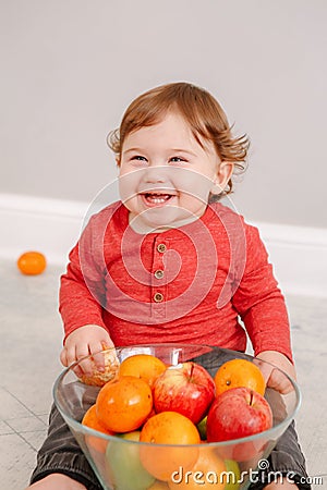 Cute adorable Caucasian baby boy eating citrus fruits. Finny child eating healthy organic snack. Solid finger food and Stock Photo