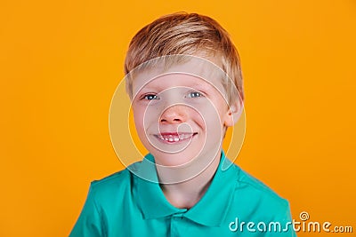 Cute adorable schoolboy wearing turquoise t-shirt on yellow background Stock Photo