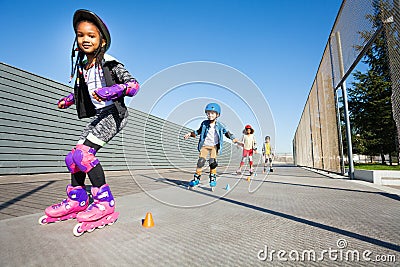 Cute African girl learning to rollerblade outdoor Stock Photo