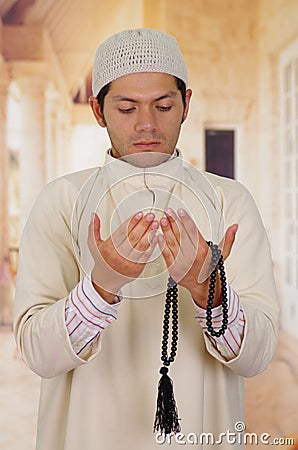 Cute arabian guy holding a masbaha with his hands Stock Photo