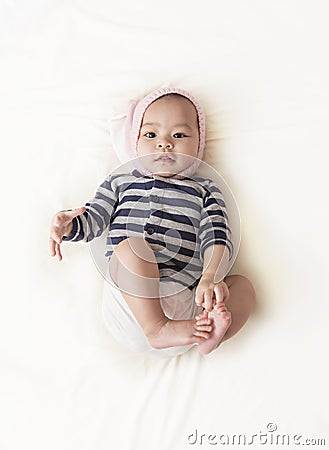 Cute Asian baby girl with pink rabbit hat on white background. Stock Photo