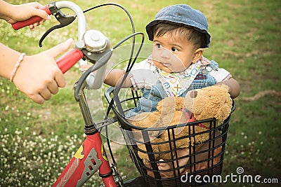 Asian baby sitting in bicycle basket,vintage tone Stock Photo