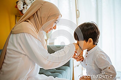 cute Asian boy kisses his mother& x27;s hand Stock Photo