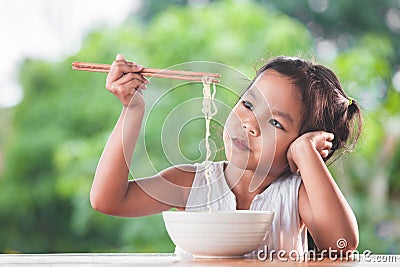 Cute asian child girl bored to eat Instant noodles Stock Photo