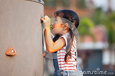 Cute asian child girl play and climbing on the rock wall Stock Photo