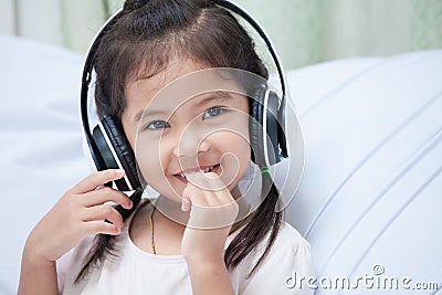 Cute asian child girl in headphones listening the music Stock Photo