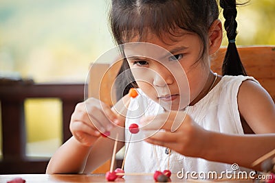 Cute asian child girl playing and creating with play dough Stock Photo