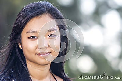 Cute asian girl smiling on blurred woods background Stock Photo