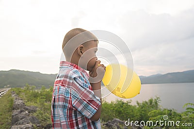 Cute asian little boy blowing balloon Stock Photo