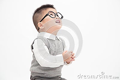 Cute Asian little boy wearing white shirt, grey vest and glasses isolated on white background. Stock Photo