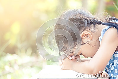 Cute asian little child girl praying with folded her hand Stock Photo