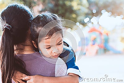 Cute asian pupil girl with backpack hugging her mother Stock Photo