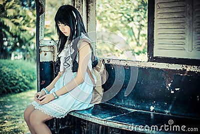 Cute Asian Thai girl in vintage clothes is waiting alone Stock Photo