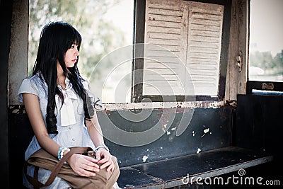 Cute Asian Thai girl in vintage clothes is waiting alone Stock Photo