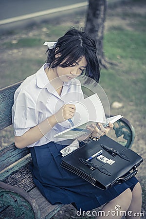 Cute Asian Thai schoolgirl student in high school uniform is sit Stock Photo