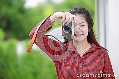 Cute Asian Thai teen girl enjoy with digital camera for hobby photographer Stock Photo