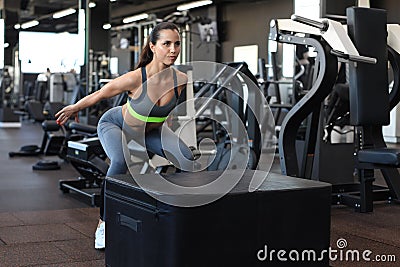 Cute athletic brunette doing jumping exercises in a cross-training gym Stock Photo