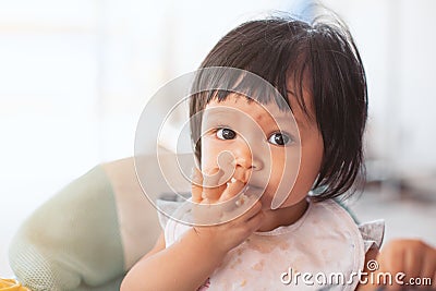 Cute baby asian child girl eating healthy food by herself Stock Photo