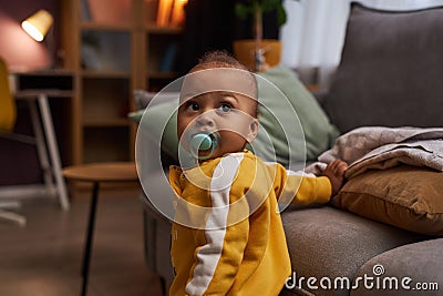 Cute baby boy with binky taking first steps Stock Photo