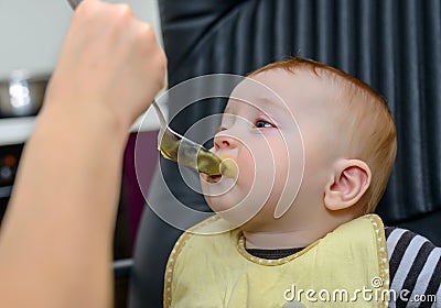 Cute Baby Boy on Chair Eating Healthy Food Stock Photo