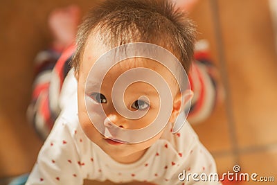 Cute baby with delicate skin looking up at you Stock Photo