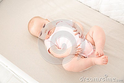 Cute baby girl in crib. Bedtime Stock Photo