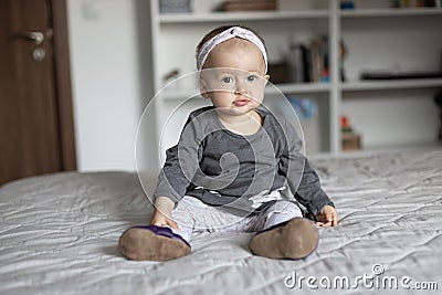 Cute baby girl with hairband ribbon. Adorable child at home Stock Photo