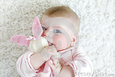 Cute baby girl playing with colorful pastel vintage rattle toy Stock Photo