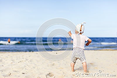 Cute baby girl pointing her finger on the ocean Stock Photo