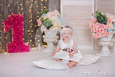 Cute baby girl 1-2 year old sitting on floor with pink balloons in room over white. Isolated. Birthday party. Celebration. Happy b Stock Photo