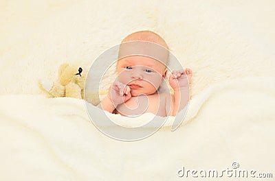 Cute baby sleeping together with teddy bear toy on bed home Stock Photo