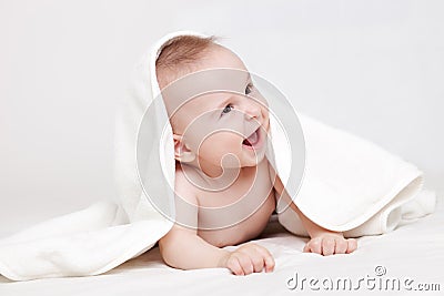 Cute baby smiling under white blanket Stock Photo