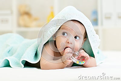 Cute baby with teether under towel indoor Stock Photo