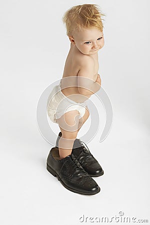 Cute Baby Wearing Men's Shoes Stock Photo