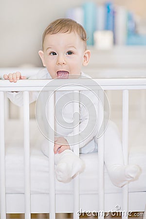 Cute baby in the white crib - portait of a lovely child Stock Photo