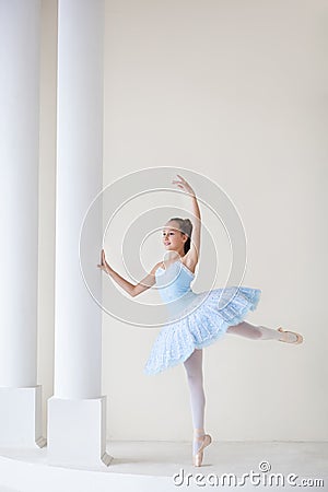 A cute ballerina in ballet costume and in pointe dances near the mirror. Girl in the dance class. The girl is studying ballet. Bal Stock Photo