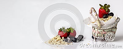 Cute basket with strawberries blueberries and oats white background Stock Photo