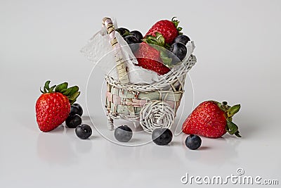 Cute basket with strawberries and blueberries white background Stock Photo