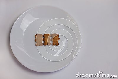 Cute bears cookies on the ceramic round plate isolated on white background. View from above, flat lay. Stock Photo