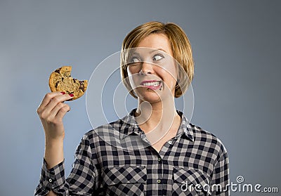 Cute beautiful woman with chocolate stain in mouth eating big delicious cookie Stock Photo