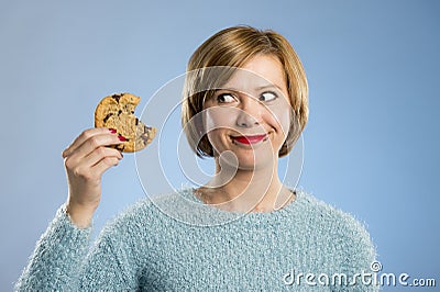 Cute beautiful woman with chocolate stain in mouth eating big delicious cookie Stock Photo