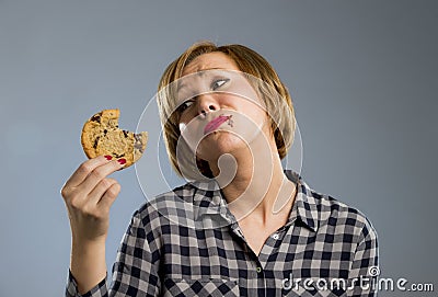 Cute beautiful woman with chocolate stain in mouth eating big delicious cookie Stock Photo