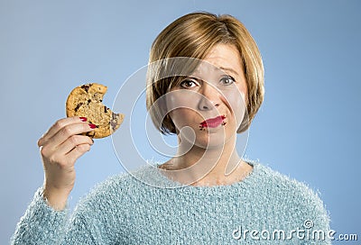 Cute beautiful woman with chocolate stain in mouth eating big delicious cookie Stock Photo