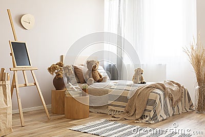 Cute bedroom with wooden design and toys, copy space on empty beige wall Stock Photo