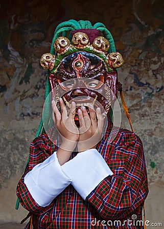 A Bhutanese boy plays with terrific demon mask which for the lama dance . Bumthang, central Bhutan. Editorial Stock Photo