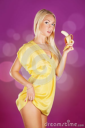 Cute blond woman holding a banana ready to eat Stock Photo