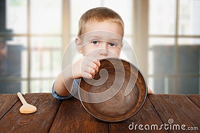 Cute blonde boy shows empty plate, hunger concept Stock Photo